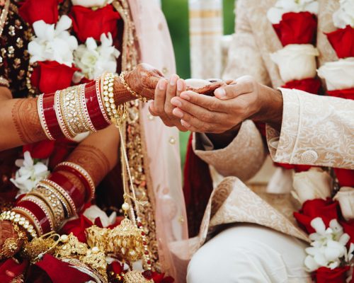 Hands of indian bride and groom intertwined together making authentic wedding ritual